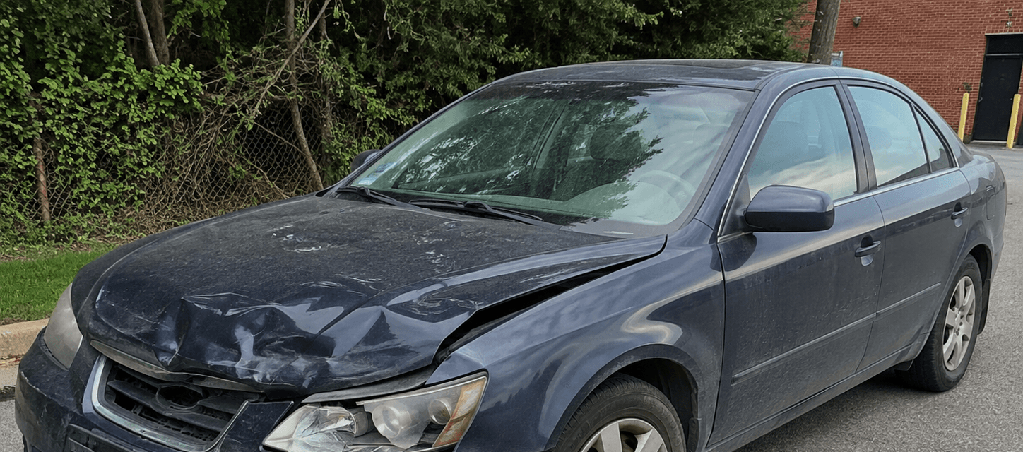 Before auto detailing: a damaged blue sedan